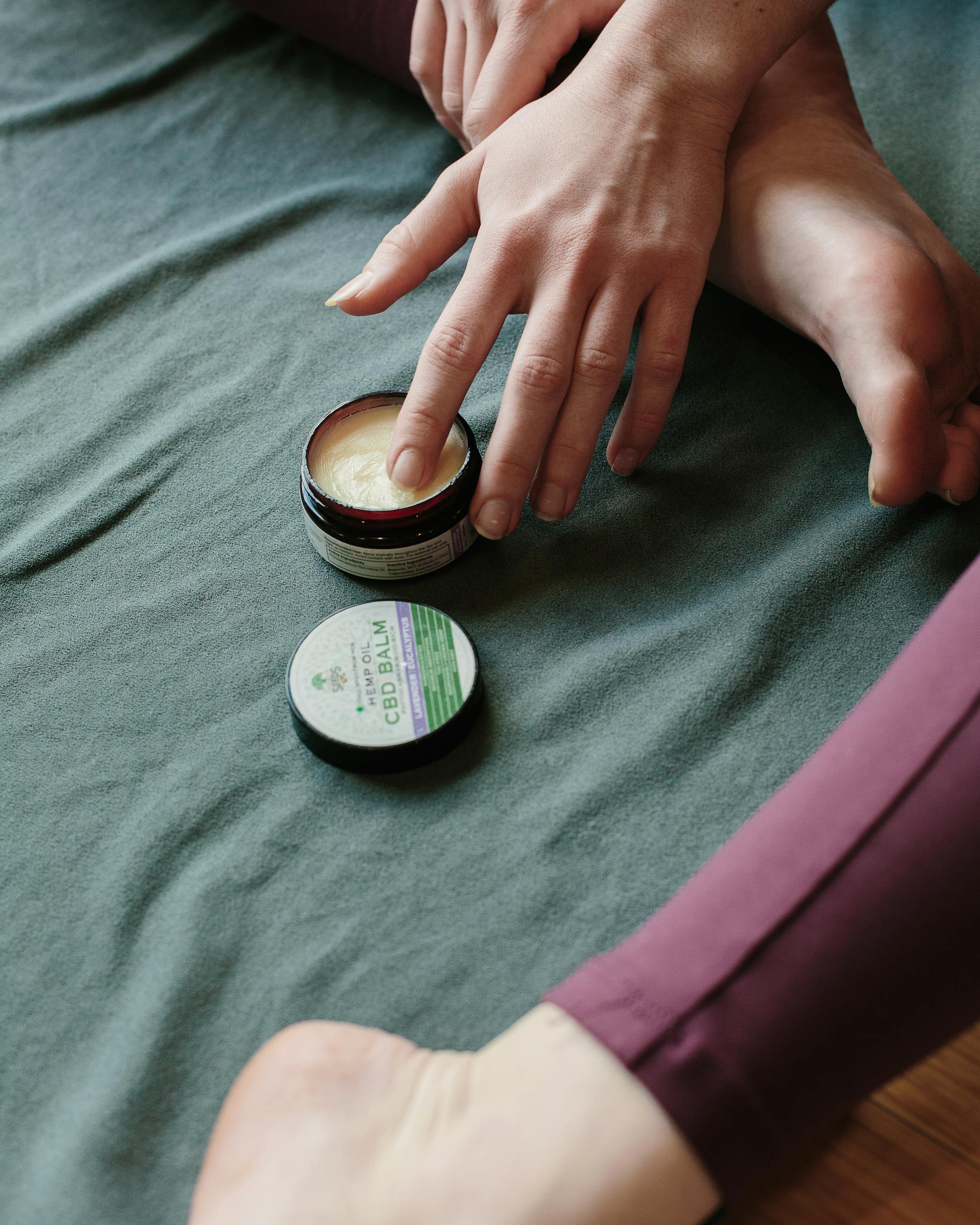 A close-up of hands applying CBD balm for stress relief and relaxation.